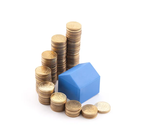 Блакитний будинок зі стопкою монет — стокове фото