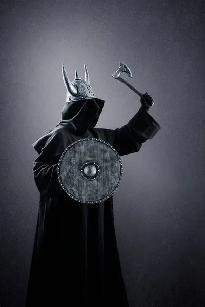 暗闇の中で角付きヘルメット 斧と丸盾を持つ戦士 — ストック写真