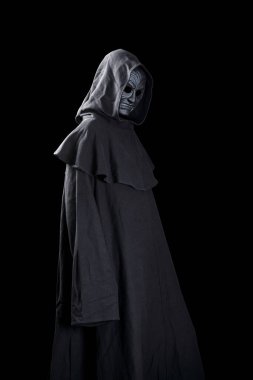 Siyah arka planda korkunç dişlerini gösteren pelerinli bir vampir.