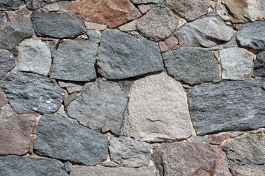 Stone wall with different colors and size of rocks