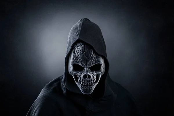 Grim reaper over dark misty background