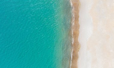 Boş beyaz kumsal ve sakin turkuaz deniz. Yukarıdaki hava görüntüsü, kopyalama alanı olan arkaplan
