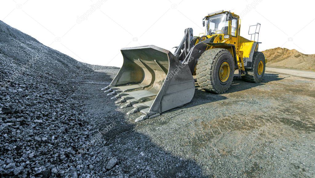 Wheel loader beside a pile of crushed gravel, cut out on white backgroun