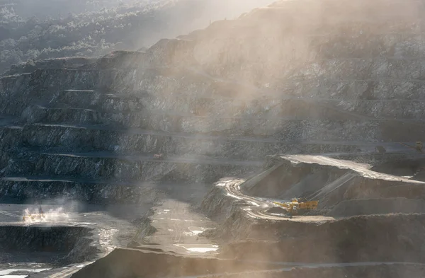 塵の雲の中の採石場で働く石の掘削機と粉砕機 — ストック写真