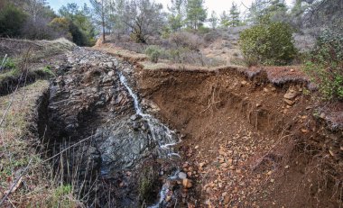 Bir orman yolunda heyelan, yer şiddetli yağış ile yıkanmış.
