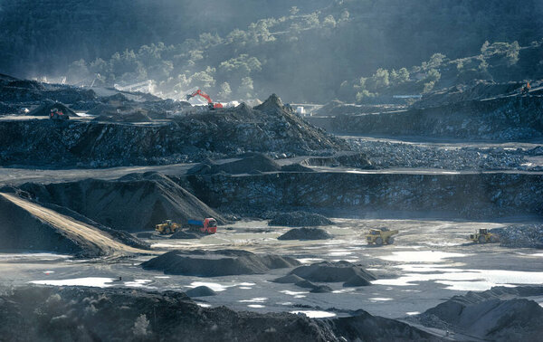 Карьер с рабочими экскаваторами, погрузчиками, карьерами и грудами щебня, промышленным ландшафтом