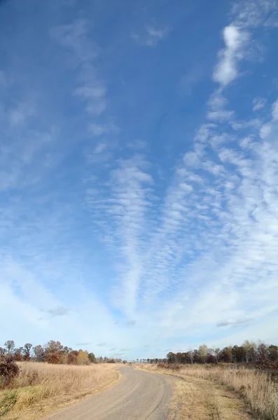 Onverharde weg met altocumulus wolken — Stockfoto