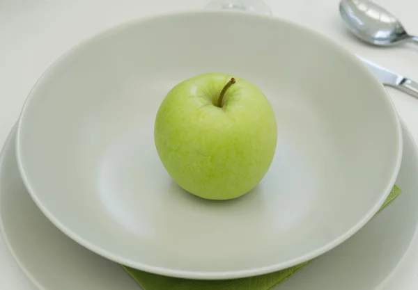 Grüner Apfel auf weißem Teller — Stockfoto