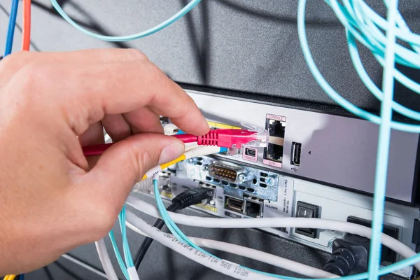 计算机技术员将补丁电缆连接到数据交换中 — 图库照片
