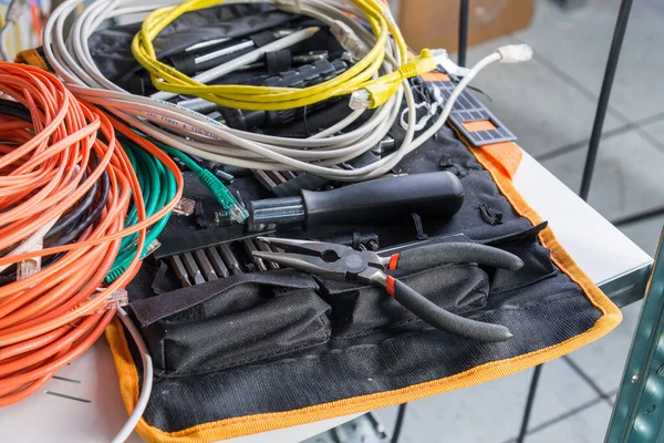 Tools with network patch and fiber optics cables with some tools of an IT engineer