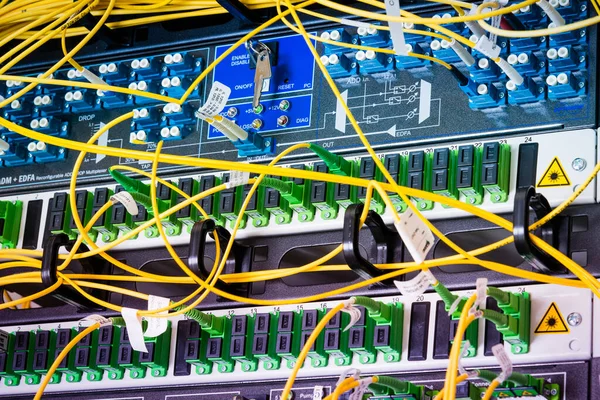 fiber optic cables plugged in network switch panels inside data center