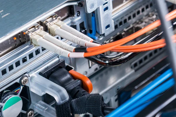 detail of server rack with fiber optic cables attached to front panel switch ports