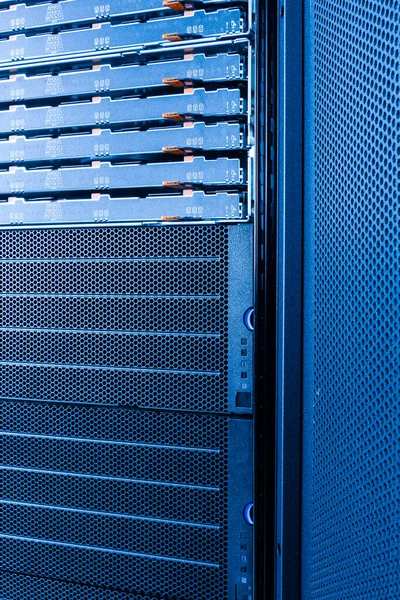 server rack with uncovered data storage arrays filled with hard drives - internet cloud provider concept