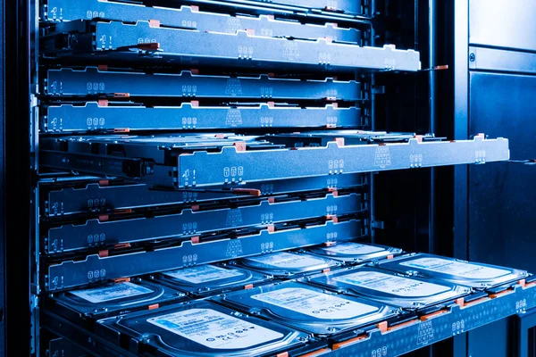 close up of hard disk drives inside hosting center - server rack filled with trays full of data storage drives