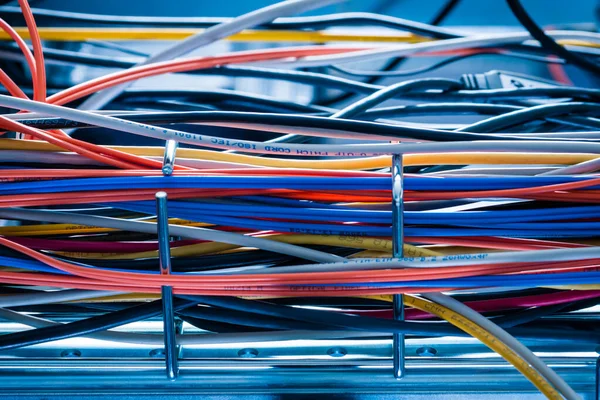 detail of large number of ethernet cables tied together connecting racks inside server room