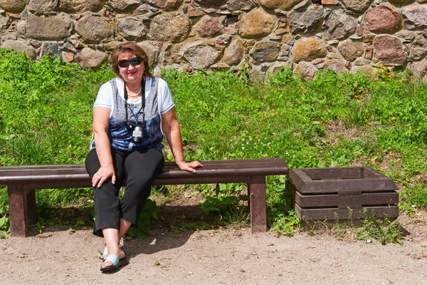 Medelålders kvinna avkopplande på en bänk — Stockfoto