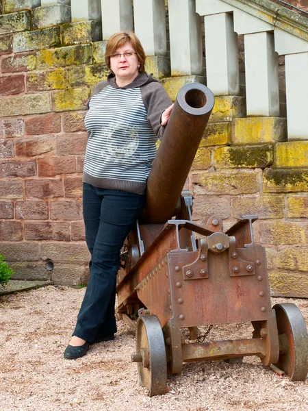 Middle-aged woman near an old cannon — Stock Photo, Image