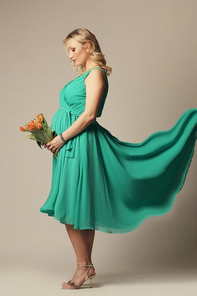 Feliz joven embarazada sosteniendo flores —  Fotos de Stock