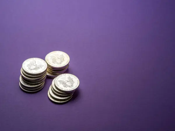 silver coins over a purple background