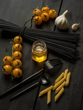 Siyah ahşap zemin üzerine makarna malzemesi.