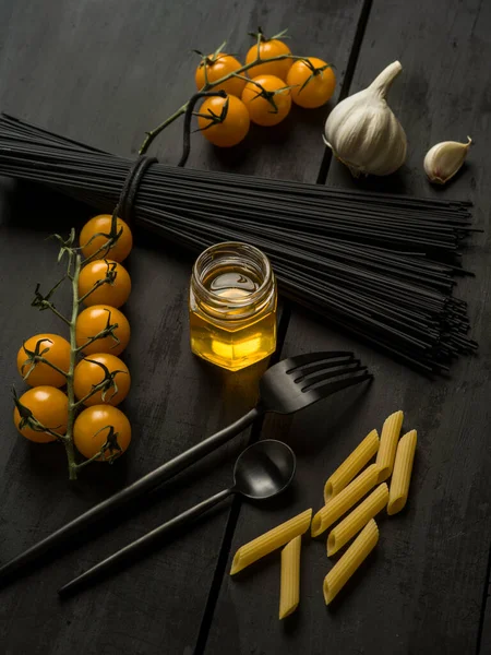 Siyah ahşap zemin üzerine makarna malzemesi.