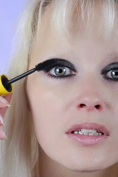 Mujer aplicando maquillaje en su cara — Foto de Stock