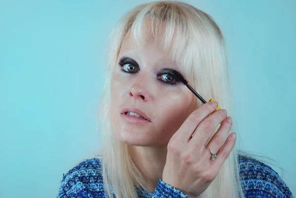 Kvinna applicera makeup på hennes ansikte — Stockfoto