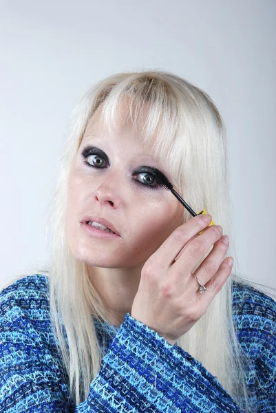 Žena nanáší make-up na obličej — Stock fotografie