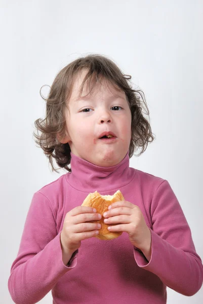 Una giovane ragazza che mangia un panino — Foto Stock