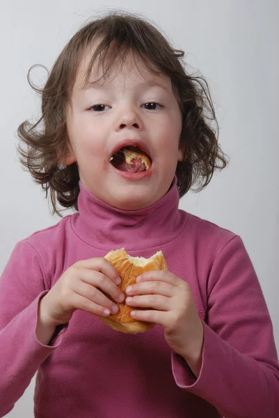 Una jovencita comiendo un bollo —  Fotos de Stock