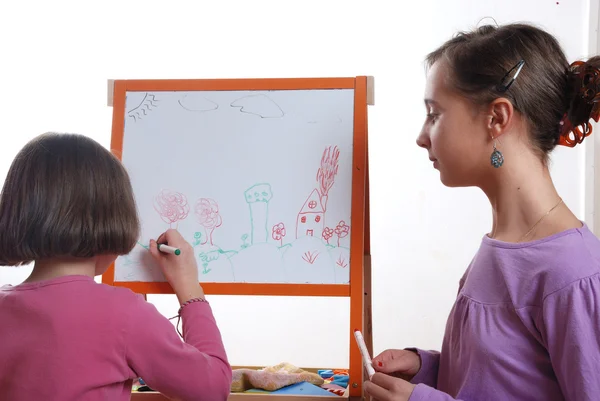 Youngs girls drawing on the white board — Stock Photo, Image