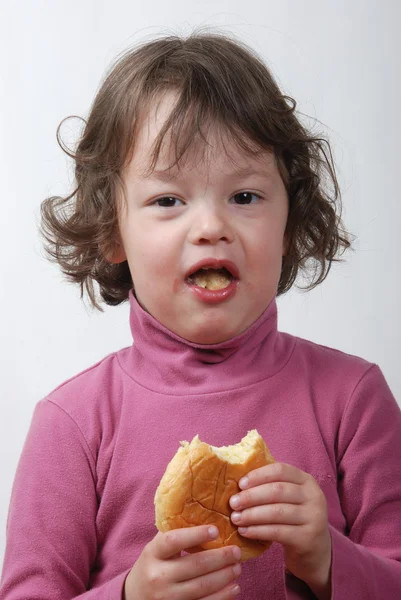 Una giovane ragazza che mangia un panino — Foto Stock