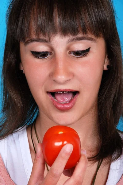 Flickan äta en tomat — Stockfoto
