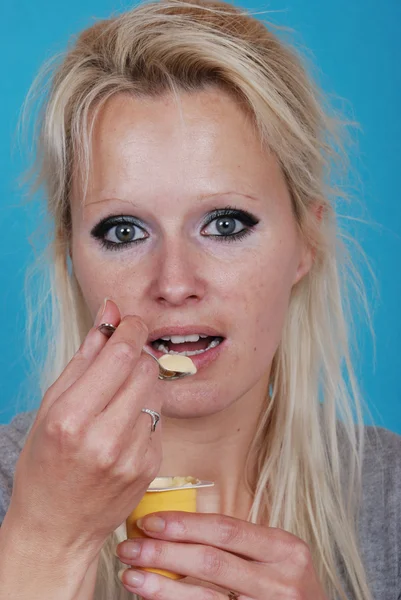 Mujer joven comer crema — Foto de Stock