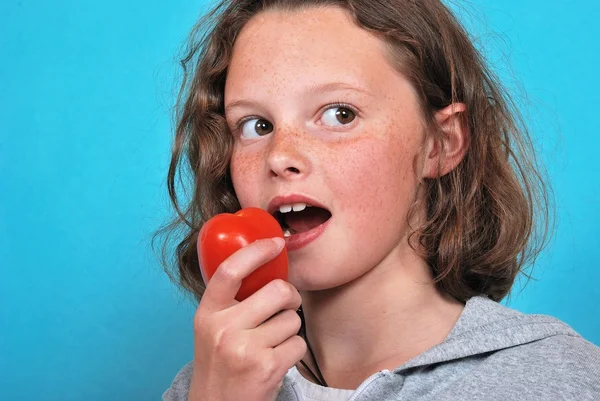 Girl eating a tomato — Stock Photo, Image