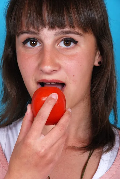 Девушка ест помидор — стоковое фото