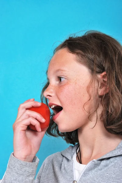 Girl eating a tomato — Stock Photo, Image