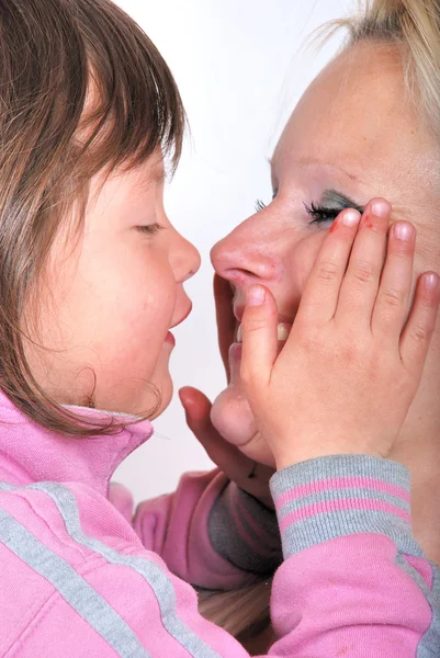 Een moeder als ze een kus van haar jonge dochter ontvangt — Stockfoto