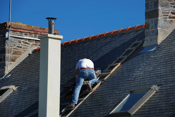 Roofer lavora accanto al camino Fotografia Stock