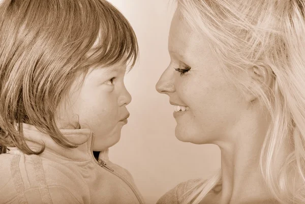 Una madre mientras recibe un beso de su hija pequeña —  Fotos de Stock
