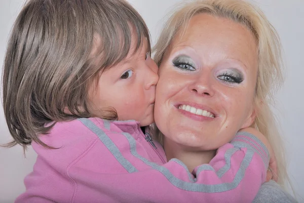 Een moeder als ze een kus van haar jonge dochter ontvangt — Stockfoto