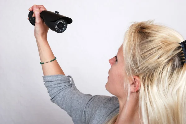 Vrouw gezicht maken op security camera — Stockfoto