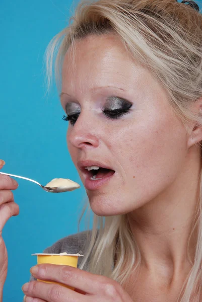 Jovem mulher comer creme de cetim — Fotografia de Stock