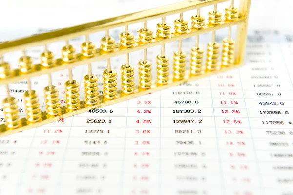 Gold abacus and statistical report — Stock Photo, Image