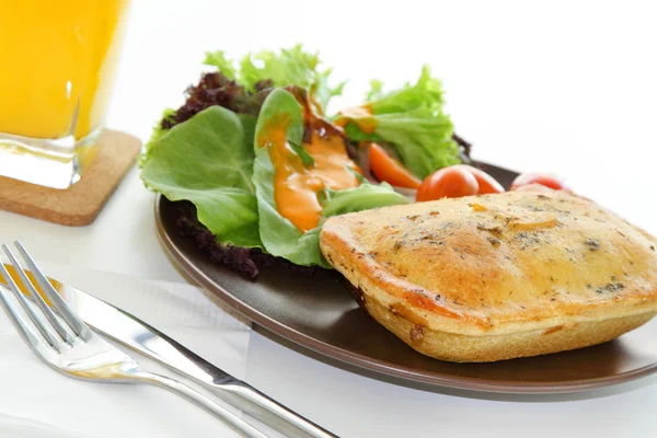 Куриный пирог с салатом и стакан апельсинового сока Стоковое Фото