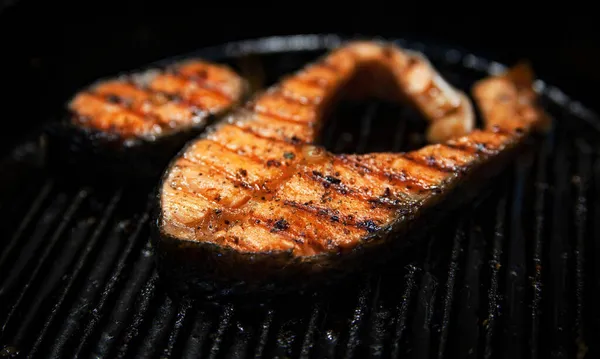 Griller le steak de poisson rouge sur une assiette sur un fond sombre — Photo