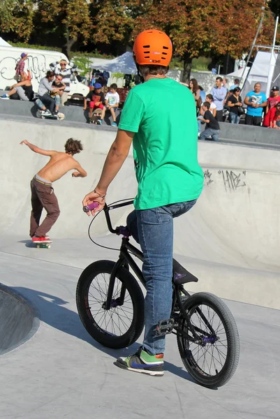 BMX cyklisty a bruslaře ve skate parku — Stock fotografie