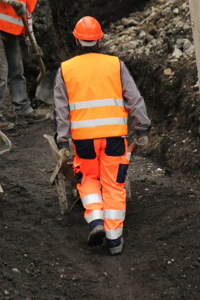 Werknemers duwen kruiwagen — Stockfoto