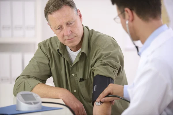 Médico verificando a pressão arterial — Fotografia de Stock