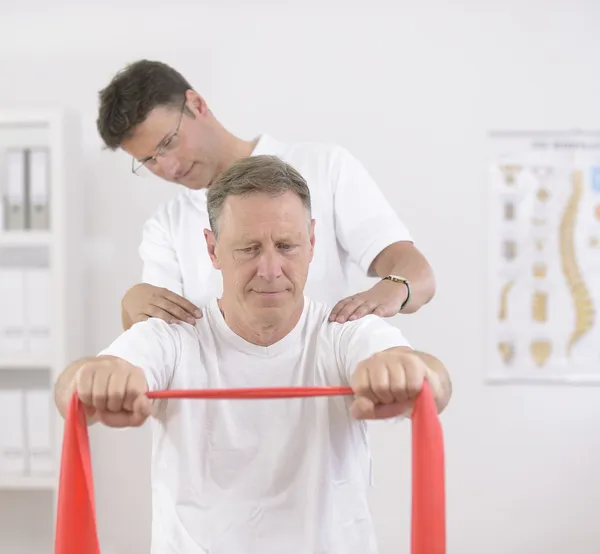 Sjukgymnastik: Senior mannen och sjukgymnast — Stockfoto